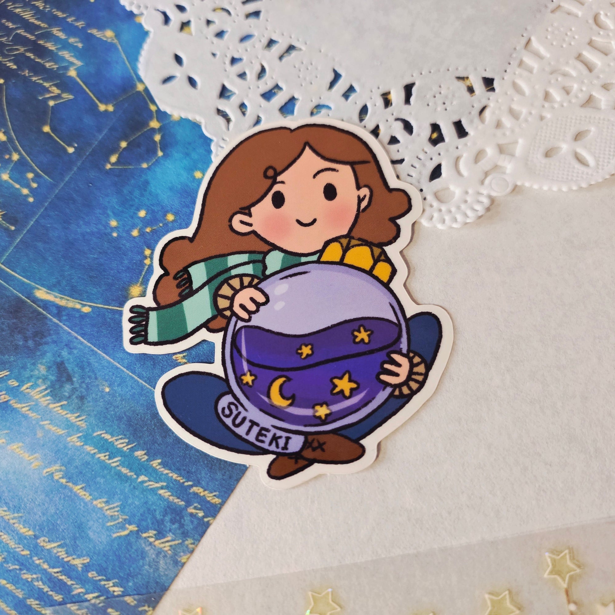 Sticker of a character holding a ink bottle with &#39;Suteki&#39; written on it, placed on a starry map background.